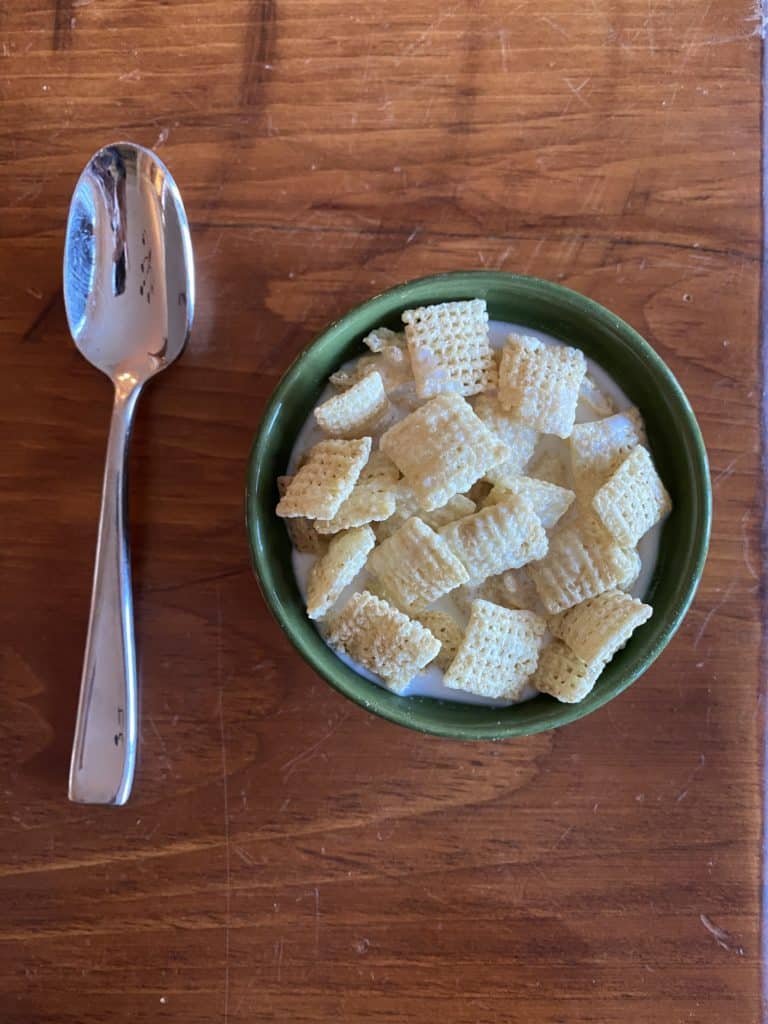 A small bowl of Rice Chex cereal with milk.